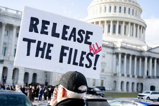 A protester holds a sign related to the release of the Jeffrey Epstein case files outside the US Capitol in Washington, DC, November 12, 2025. (Photo by SAUL LOEB / AFP) (Photo by SAUL LOEB/AFP via Getty Images)