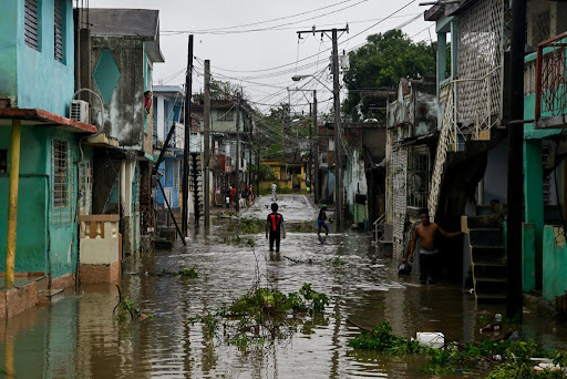 Residents stand in a flooded street, in the aftermath of Hurricane Melissa, in Santiago, Cuba, October 29, 2025. REUTERS/Norlys Perez