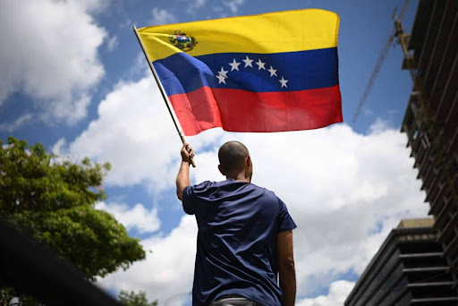 TOPSHOT - A man waves a Venezuelan flag during a protest called by the opposition for election 'victory' to be recognised, in Caracas on August 17, 2024. (Photo by Federico PARRA / AFP) (Photo by FEDERICO PARRA/AFP via Getty Images)