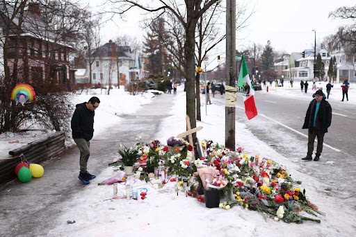 People gather at a makeshift memorial for 37-year-old Renee Nicole Good, who was shot and killed at point blank range on January 7 by a US Immigration and Customs Enforcement (ICE) agent as she apparently tried to drive away from agents who were crowding around her car, in Minneapolis, Minnesota, on January 8, 2026. A US Immigration and Customs Enforcement (ICE) agent shot and killed an American woman on the streets of Minneapolis January 7, leading to huge protests and outrage from local leaders who rejected White House claims she was a domestic terrorist. (Photo by CHARLY TRIBALLEAU / AFP via Getty Images)
