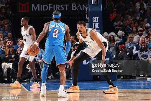 OKLAHOMA CITY, OK - JANUARY 13: Victor Wembanyama #1 of the San Antonio Spurs plays defense on Shai Gilgeous-Alexander #2 of the Oklahoma City Thunder during the game on January 13, 2026 at Paycom Center in Oklahoma City, Oklahoma. NOTE TO USER: User expressly acknowledges and agrees that, by downloading and or using this photograph, User is consenting to the terms and conditions of the Getty Images License Agreement. Mandatory Copyright Notice: Copyright 2026 NBAE (Photo by Zach Beeker/NBAE via Getty Images)