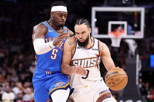 Dillon Brooks of the Phoenix Suns is taking contact from Lu Dort of the Oklahoma City Thunder.